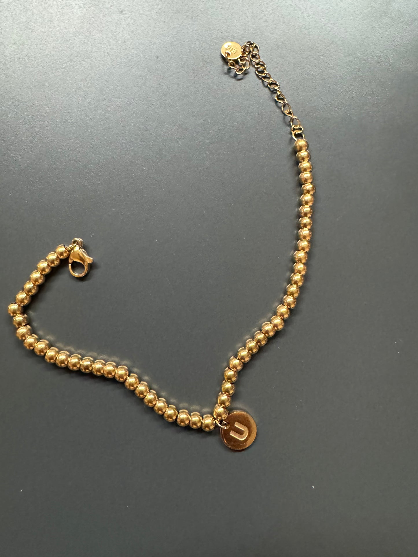 Gold bead bracelet with charm