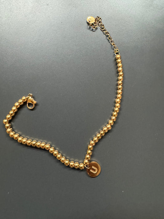 Gold bead bracelet with charm